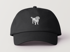 Front view of black cap with white embroidered Toto the Dog design